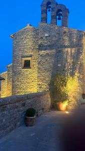 un edificio de piedra con una torre con un reloj. en Convivio Etrusco en Bassano in Teverina