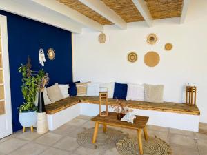 a living room with a bench and a blue wall at Gîte E & M in Saint-Denis-de-Pile