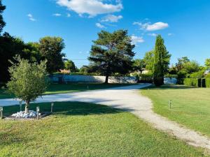a gravel road in a park with a tree at Gîte E & M in Saint-Denis-de-Pile