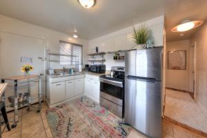 a kitchen with white cabinets and a stainless steel refrigerator at Desert Gardens #1 in Moab