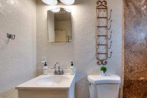 a bathroom with a sink and a toilet and a mirror at Desert Gardens #1 in Moab +21 photos