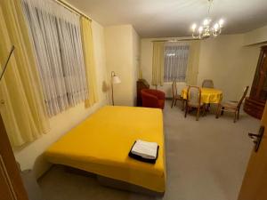 a room with a yellow bed and a table and chairs at Ruhige Ferienwohnung Lutherstraße in Rudolstadt