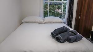 a bed with a towel on it with a window at Wonderful cozy double room-Only Room in London