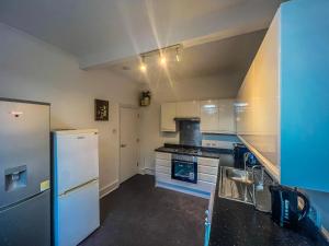 a kitchen with white appliances and a blue wall at Wonderful cozy double room-Only Room in London