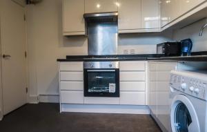 a kitchen with a stove and a washing machine at Wonderful cozy double room-Only Room in London