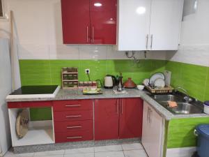 una cocina con armarios rojos y verde y blanco en Sotto ma carino, en Temara