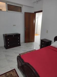 1 dormitorio con cama roja y vestidor en Sotto ma carino, en Temara