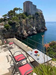 a table and chairs sitting on a patio overlooking the ocean at Villa Kolorina in Dubrovnik