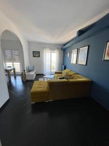 1 dormitorio con cama amarilla y pared azul en Appartamento Terrazza Bella Vista, en Cisternino