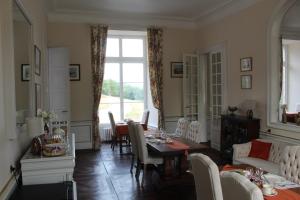 a living room with a table and a dining room at Chateau de la Lucazière in Mont-Saint-Jean