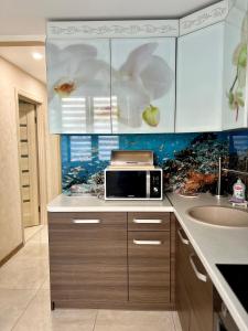 a kitchen with a sink and a microwave at Avenue Apart in Lviv +24 photos