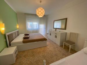 a bedroom with a bed and a table and a chair at Adelina's Delux Apartament Durres in Durrës