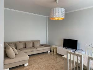 a living room with a couch and a tv at Adelina's Delux Apartament Durres in Durrës