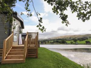 a deck with a view of a lake at Astoria Lodge in Clitheroe