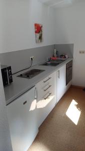 a kitchen with white cabinets and a counter top at Ferienwohnung Funkner 