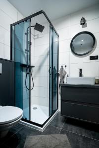 ein Bad mit einer Glasdusche und einem WC in der Unterkunft Apartament La Lemur in Nowy Sącz