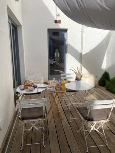 a patio with two tables and chairs on a deck at LUVIA ROOMS SPA in Gonnesa