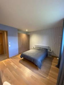 - une chambre avec un lit et du parquet dans l'établissement Maison ossature bois, à Dole