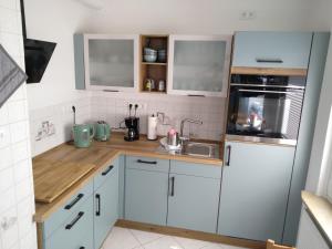 a small kitchen with white cabinets and a sink at Ferienhaus Eckernfeld Bremerhaven in Bremerhaven
