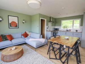 a living room with a couch and a table at Beech Cottage in Aberfeldy