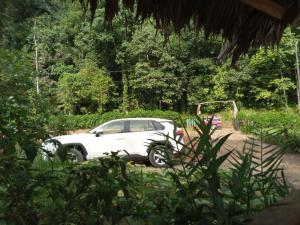 una macchina bianca parcheggiata accanto a una palla da golf di Cabinas jugle jause a Bahía Drake