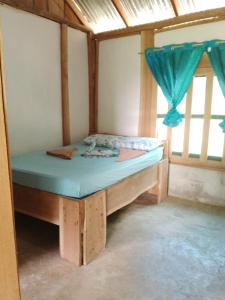 un piccolo letto in una camera con finestra di Cabinas jugle jause a Bahía Drake