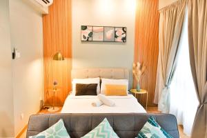 Kuantan Imperium Residence Cityview With Netflix في كُوانتان: غرفة نوم بسرير واريكة