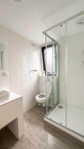 a bathroom with a toilet and a glass shower at Hotel zum Hahn in Garbsen