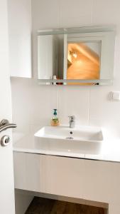a white bathroom with a sink and a mirror at Hotel zum Hahn in Garbsen