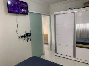 ein Wohnzimmer mit einem TV an der Wand und einer Kamera in der Unterkunft Quitinete Aconchegante Prq Pelinca in Campos dos Goytacazes