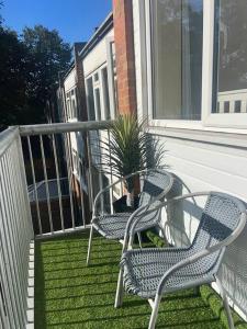 zwei Stühle auf einer Veranda mit Topfpflanze in der Unterkunft 2 Bedroom Apartment with Balcony in Oxford