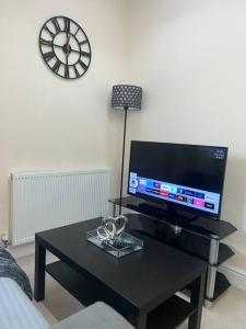 a living room with a black coffee table and a tv at 2 Bedroom Apartment with Balcony in Oxford