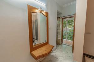een badkamer met een spiegel aan de muur bij HomeSlice Yellow in Bangalore