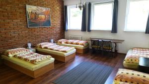 a room with four beds and a brick wall at Ubytovanie KAMENICA 