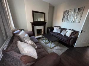 uma sala de estar com dois sofás e uma lareira em 3 Bedroom House on Beatles Famous Road em Liverpool