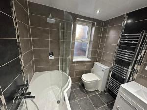 a bathroom with a bath tub and a toilet at 3 Bedroom House on Beatles Famous Road in Liverpool