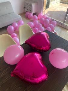 Habitación con globos rosas y almohadas rosas en una mesa. en CAN TRULLEN CHALET CALAFELL en Calafell