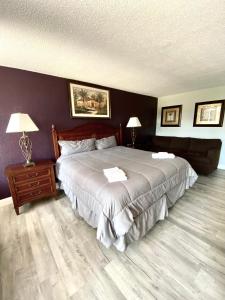 a bedroom with a large bed and a wooden floor at Heritage Park Inn in Kissimmee