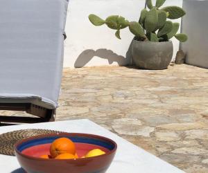 Eine Schale Orangen auf einem Tisch mit einer Pflanze in der Unterkunft Sofithea in Kythnos