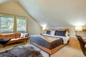 een slaapkamer met een bed en een bank bij Stylish Angel Fire Cabin with Deck - 2 Mi to Ski Mtn in Angel Fire
