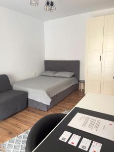 a small bedroom with a bed and a couch at Puzzle Studio in Bucharest