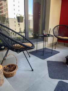 a chair and a table on a balcony at Puzzle Studio in Bucharest