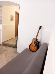 una guitarra sentada en un sofá en una habitación en 'Al Vico Dante' en Loceri