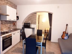 eine Küche mit einem Tisch und eine Küche mit einer Gitarre in der Unterkunft 'Al Vico Dante' in Loceri
