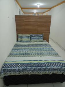 a bedroom with a large bed with a wooden headboard at Aconchego da Kika in Caruaru