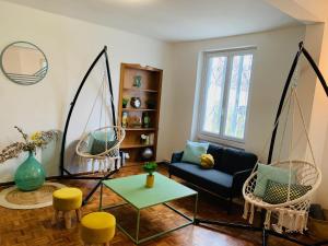 uma sala de estar com duas cadeiras de baloiço e uma mesa em cosy studio design with modern bathroom em Vauréal