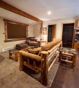 a living room with a large couch and a tv at Deckers South Platte River Cabin 