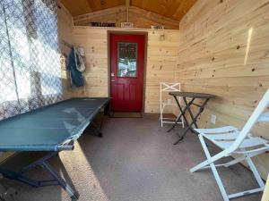 a room with a ping pong table and a red door at Deckers South Platte River Cabin 