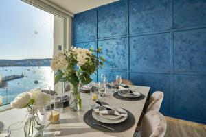 una sala da pranzo con tavolo e parete blu di Lux Villa with Pool-Hosted by Sweetstay a San Pawl il-Baħar