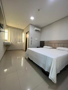 a bedroom with a large white bed in a room at Hotel PetroShop in Palmas